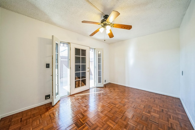 spare room with ceiling fan, dark parquet flooring, and a textured ceiling