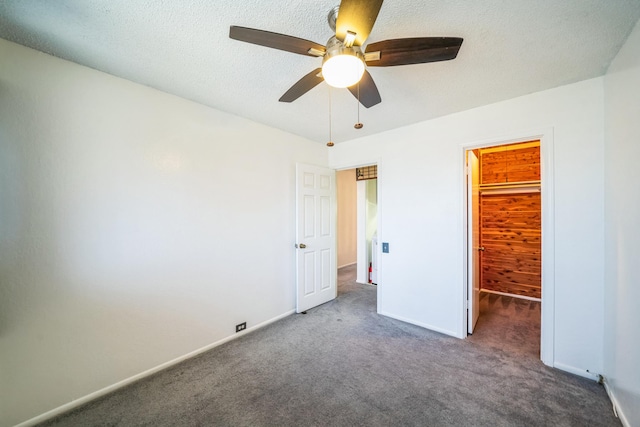 unfurnished bedroom featuring ceiling fan, dark carpet, a closet, and a textured ceiling