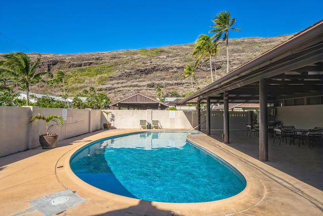 view of swimming pool with a mountain view and a patio area