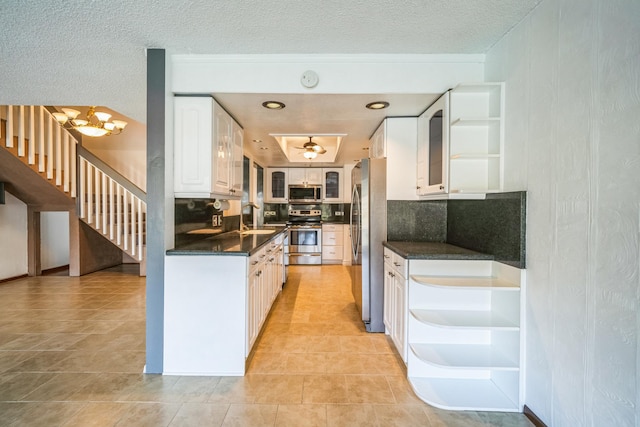 kitchen featuring sink, backsplash, stainless steel appliances, white cabinets, and a textured ceiling