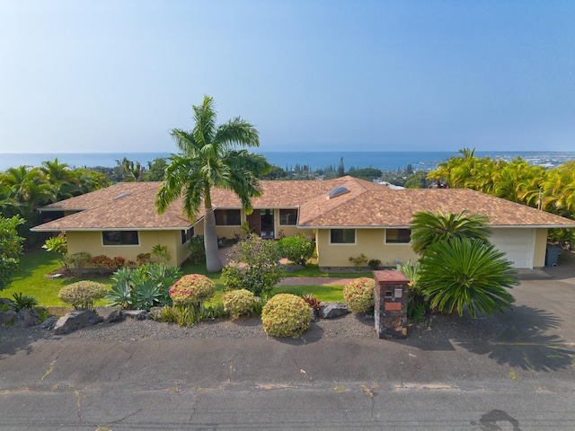 ranch-style house featuring a garage and a water view