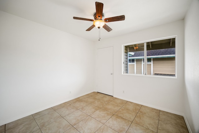 spare room with light tile patterned flooring and ceiling fan