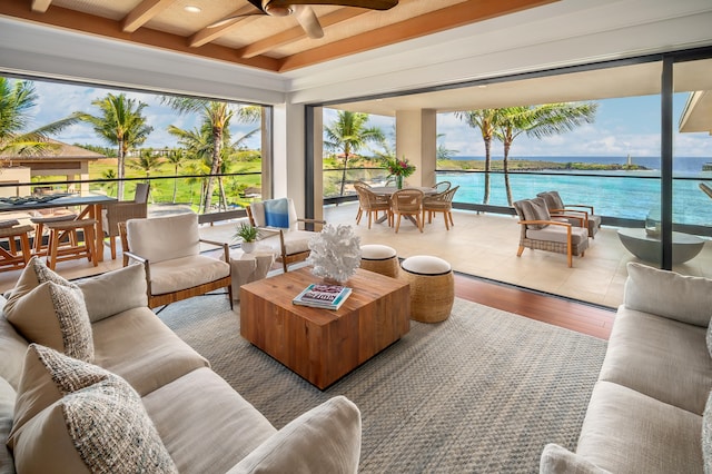 sunroom featuring beamed ceiling, a water view, and ceiling fan