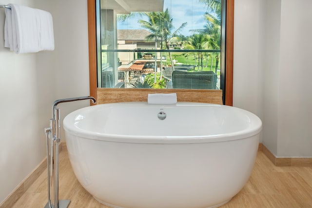 bathroom with a wealth of natural light and a tub