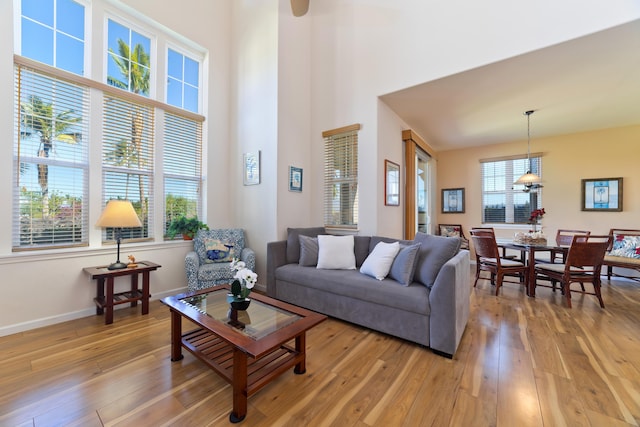 living room with a high ceiling and light wood-type flooring