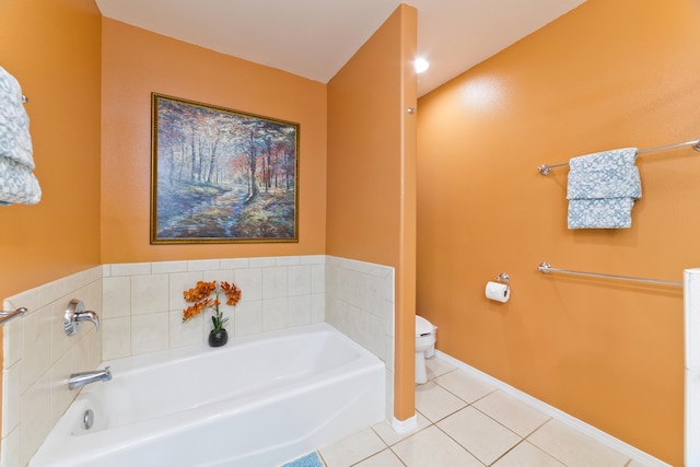 bathroom with a tub to relax in, tile patterned floors, and toilet