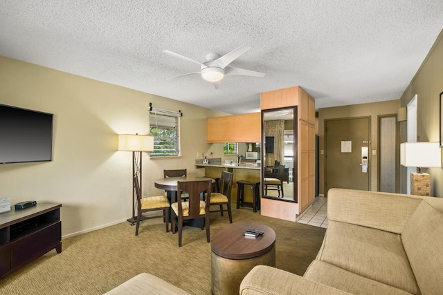 living room featuring light carpet, a textured ceiling, and ceiling fan