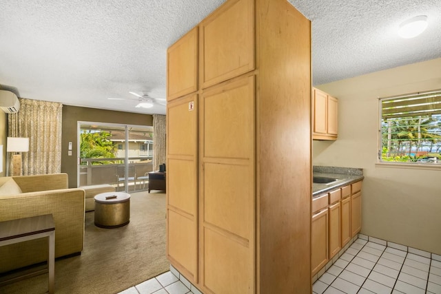 kitchen with ceiling fan, light tile patterned floors, a textured ceiling, and light brown cabinetry