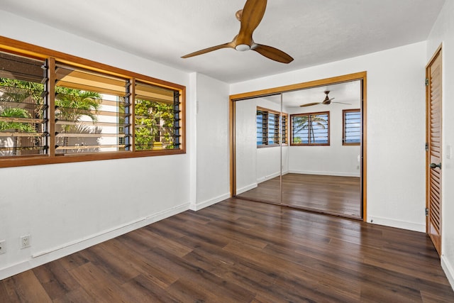 unfurnished room featuring wood finished floors, a wealth of natural light, baseboards, and ceiling fan