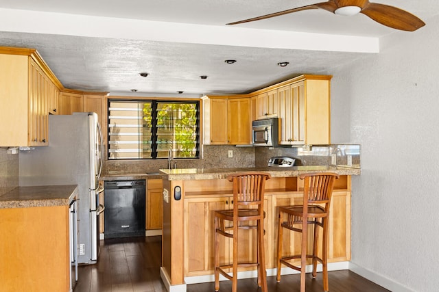 kitchen featuring backsplash, dishwasher, a peninsula, baseboards, and dark wood-style flooring