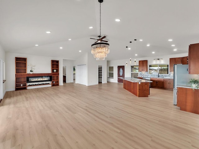 kitchen featuring decorative light fixtures, a kitchen island, and light wood-type flooring