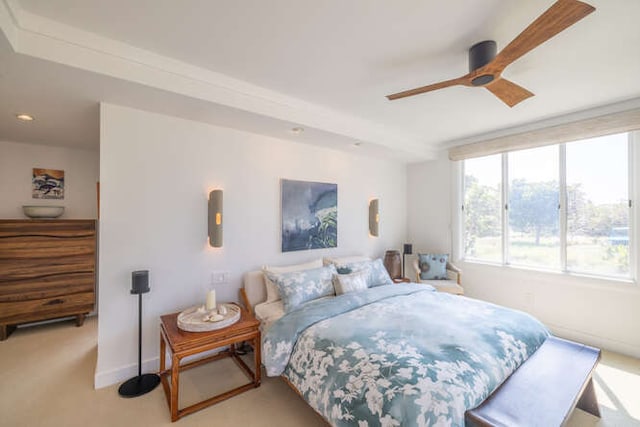 bedroom featuring a ceiling fan, light carpet, and baseboards