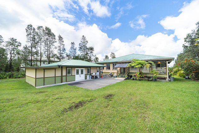 rear view of property featuring a patio and a lawn