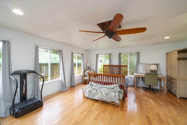 bedroom featuring ceiling fan, light hardwood / wood-style floors, and multiple windows