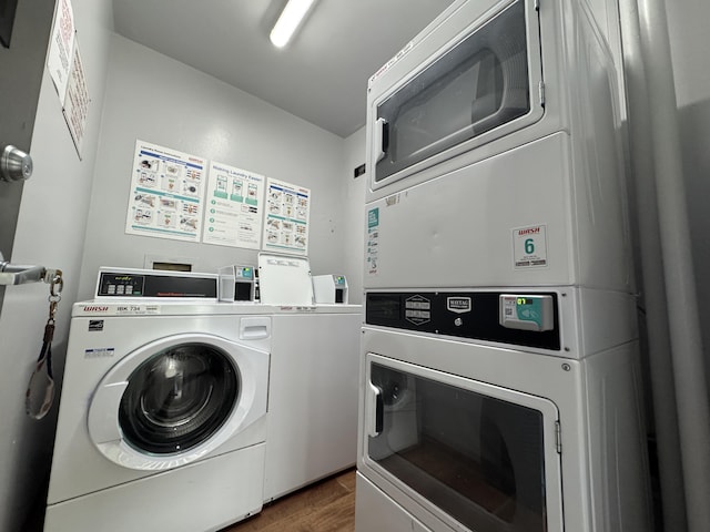 clothes washing area with stacked washer / dryer, washer and dryer, and dark wood-type flooring