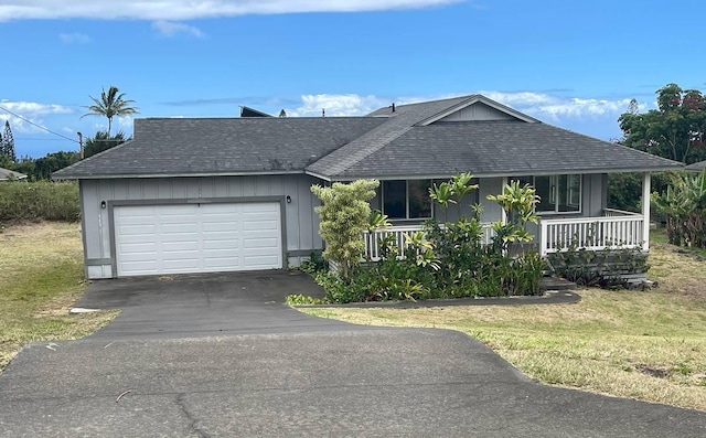 single story home with a garage, covered porch, and a front lawn