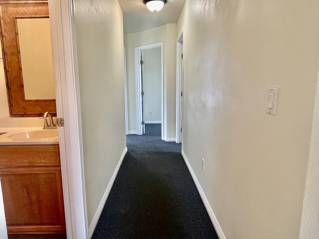 hallway with sink and carpet floors