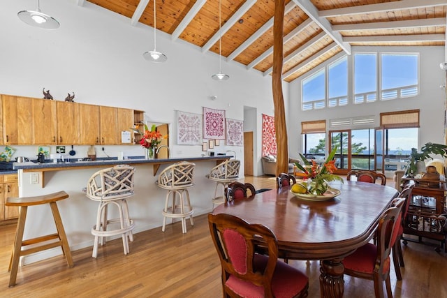 dining room featuring wood ceiling, lofted ceiling with beams, and light hardwood / wood-style flooring