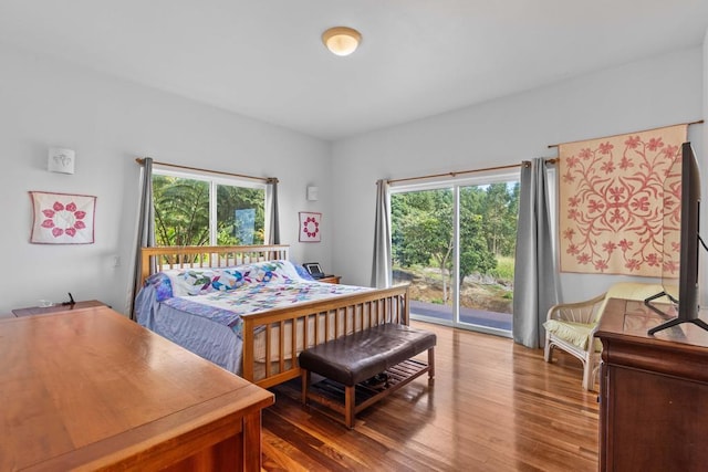 bedroom featuring access to exterior and hardwood / wood-style flooring