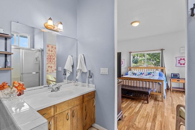 bathroom with vanity, hardwood / wood-style floors, and a shower with door