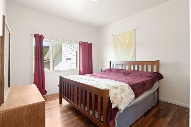 bedroom with dark hardwood / wood-style floors