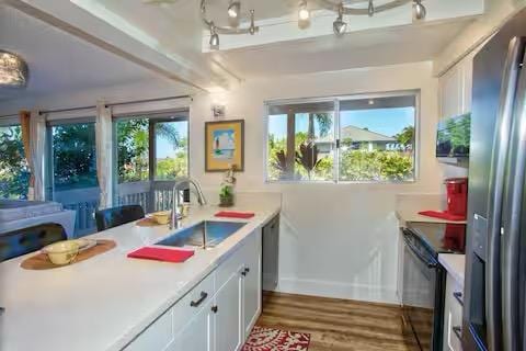 kitchen featuring sink, light hardwood / wood-style flooring, stainless steel appliances, and white cabinets