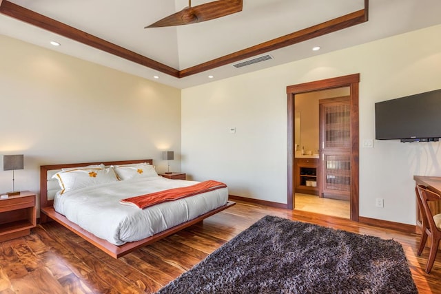 bedroom with hardwood / wood-style flooring and ensuite bath