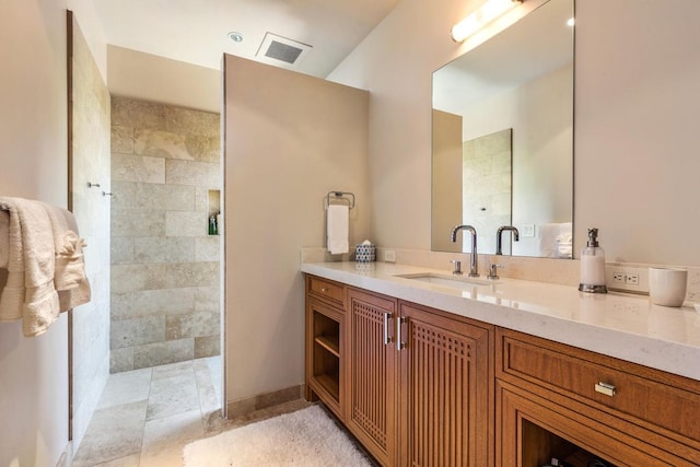 bathroom with vanity and a tile shower