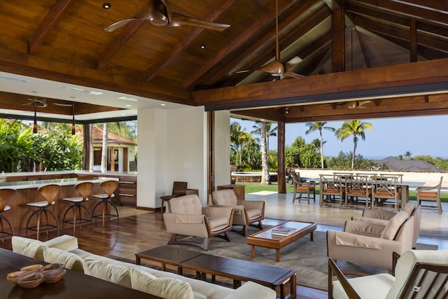 interior space featuring hardwood / wood-style floors, wood ceiling, lofted ceiling with beams, and ceiling fan