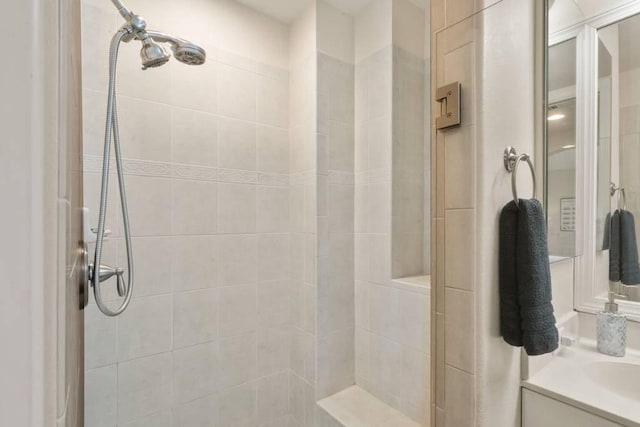 bathroom with vanity and tiled shower