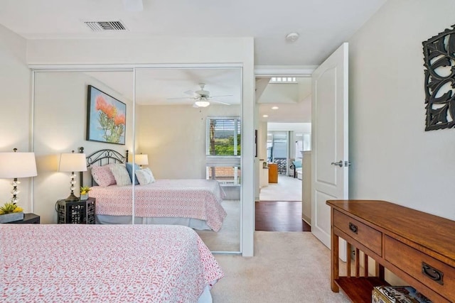 carpeted bedroom with ceiling fan and a closet