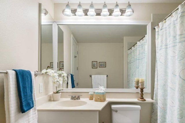 bathroom featuring vanity, curtained shower, and toilet