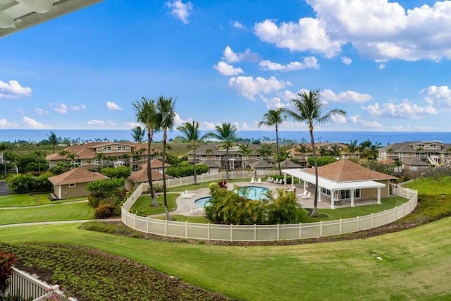 view of property's community with a water view and a lawn