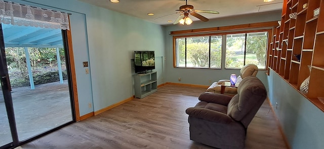 living room with light hardwood / wood-style floors and ceiling fan