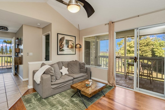 living room featuring ceiling fan, vaulted ceiling, light hardwood / wood-style floors, and a healthy amount of sunlight