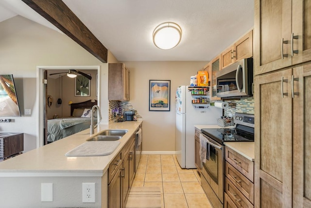 kitchen featuring sink, light tile patterned floors, appliances with stainless steel finishes, tasteful backsplash, and lofted ceiling with beams