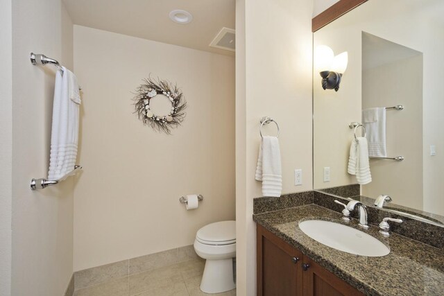 bathroom featuring vanity, tile patterned floors, and toilet