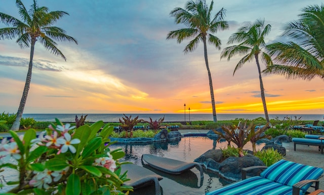 patio terrace at dusk featuring a water view