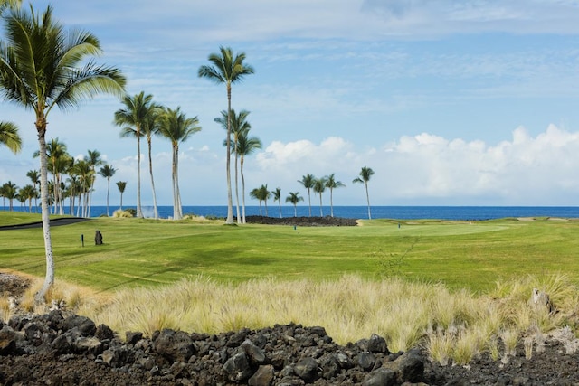 view of property's community with a lawn and a water view