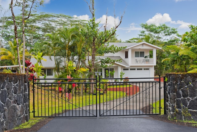 view of gate with a garage and a yard