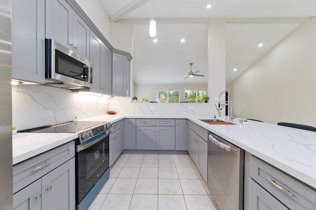 kitchen with appliances with stainless steel finishes, sink, and gray cabinetry