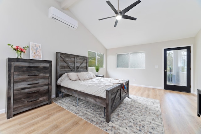 bedroom with multiple windows, a wall mounted air conditioner, light hardwood / wood-style floors, and beam ceiling