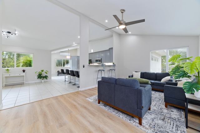 living room featuring high vaulted ceiling, light hardwood / wood-style floors, and ceiling fan