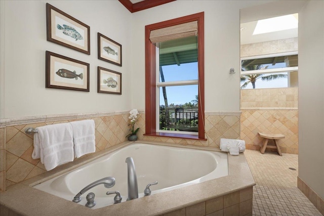 bathroom with plenty of natural light and tiled bath