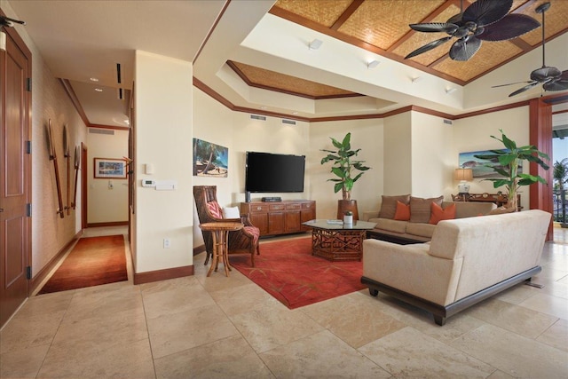 living room with a tray ceiling, crown molding, and ceiling fan