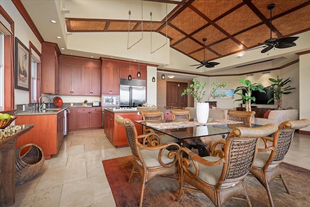 dining area with sink, a towering ceiling, and ceiling fan