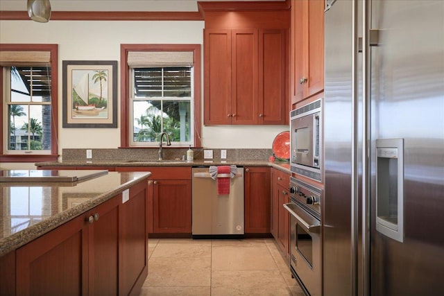 kitchen with light stone counters, sink, and stainless steel appliances