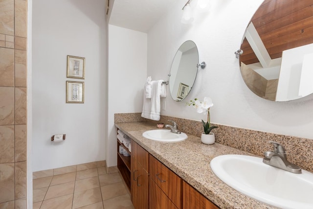 full bathroom with double vanity, a sink, and tile patterned floors