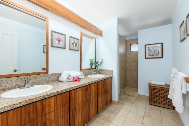 bathroom with double vanity, walk in shower, a sink, and tile patterned floors