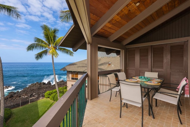 balcony with outdoor dining space and a water view